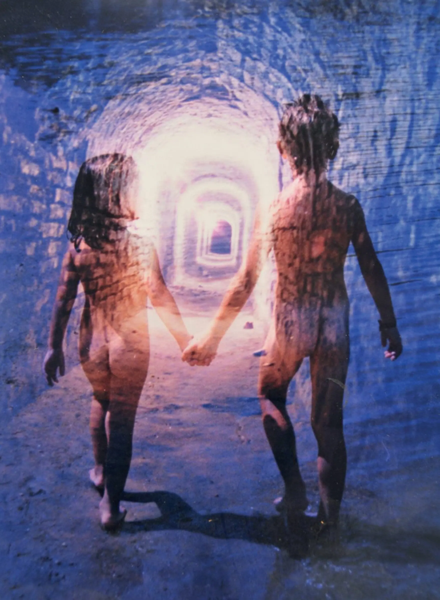 Fotografía La Vida: dos niños de espaldas caminan de la mano hacia la luz al final de un túnel