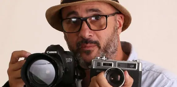 Marcelo Cattani sostiene una cámara Canon y una Yashica de visor directo