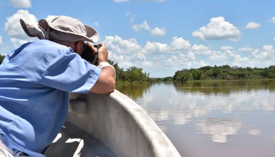Marcelo fotografía el río desde la proa de una lancha