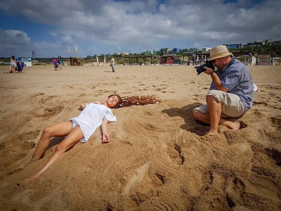 Marcelo fotografía a una modelo recostada en la arena de una playa